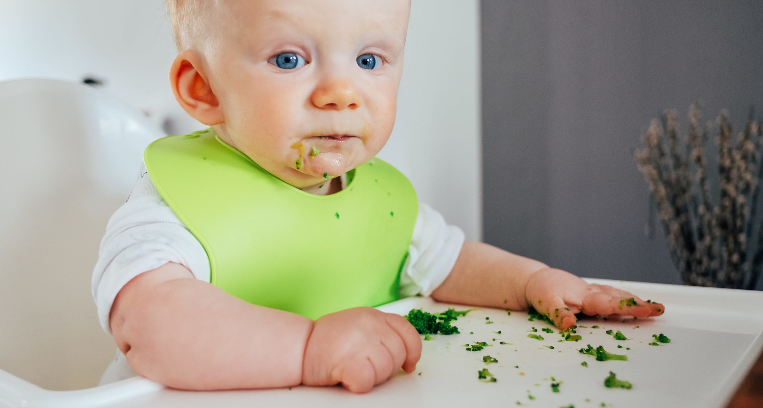 Portrait of cute baby girl sitting messy after feeding